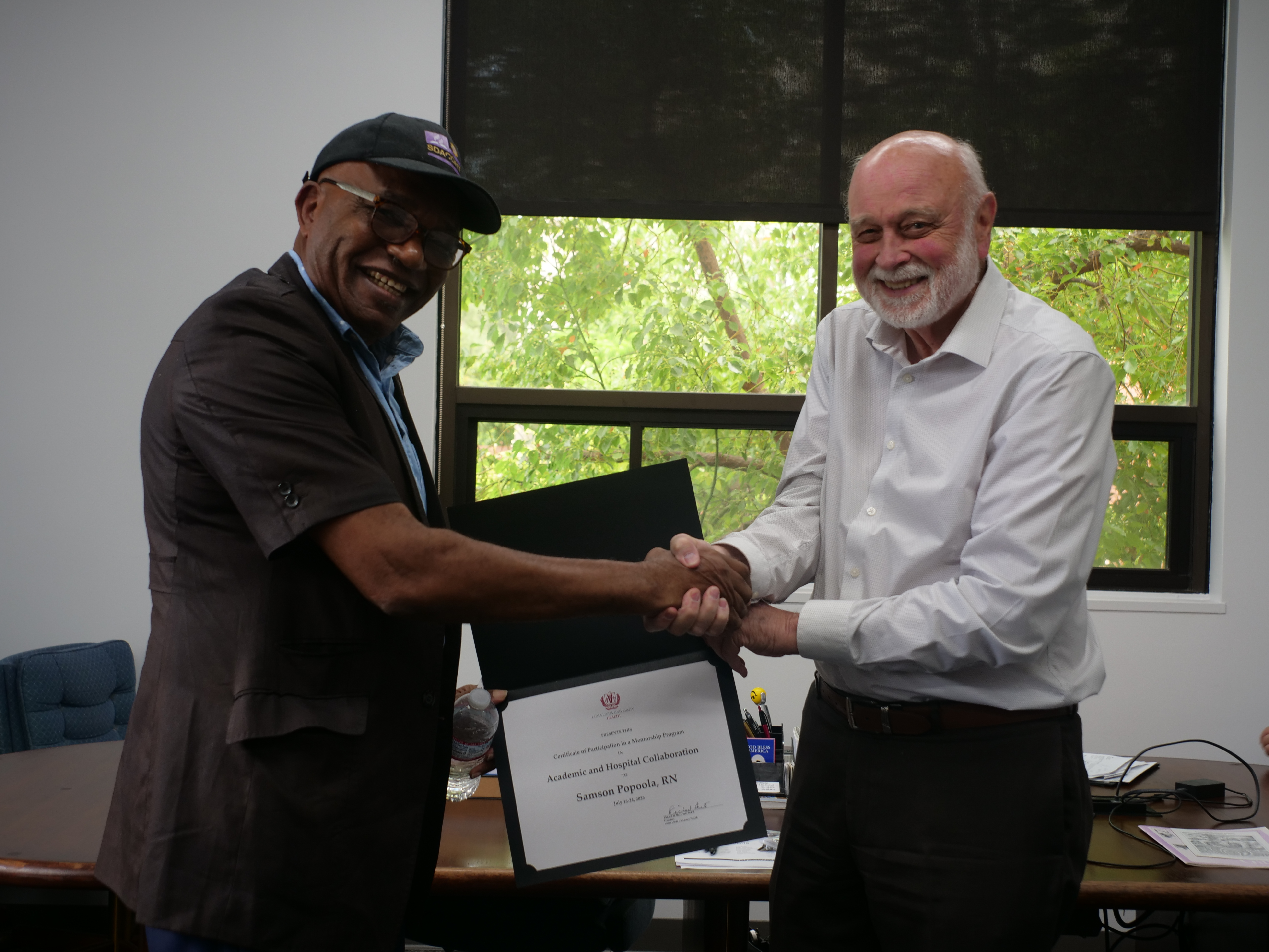 Dr. Richard Hart presents a Certificate of Participation in Academic and Hospital Collaboration to Samson Popoola.