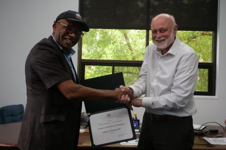 Dr. Richard Hart presents a Certificate of Participation in Academic and Hospital Collaboration to Samson Popoola.