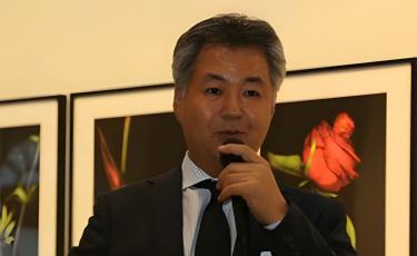 man in suit speaking in microphone