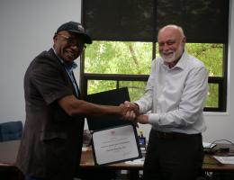 Dr. Richard Hart presents a Certificate of Participation in Academic and Hospital Collaboration to Samson Popoola.