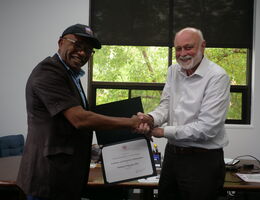 Dr. Richard Hart presents a Certificate of Participation in Academic and Hospital Collaboration to Samson Popoola.